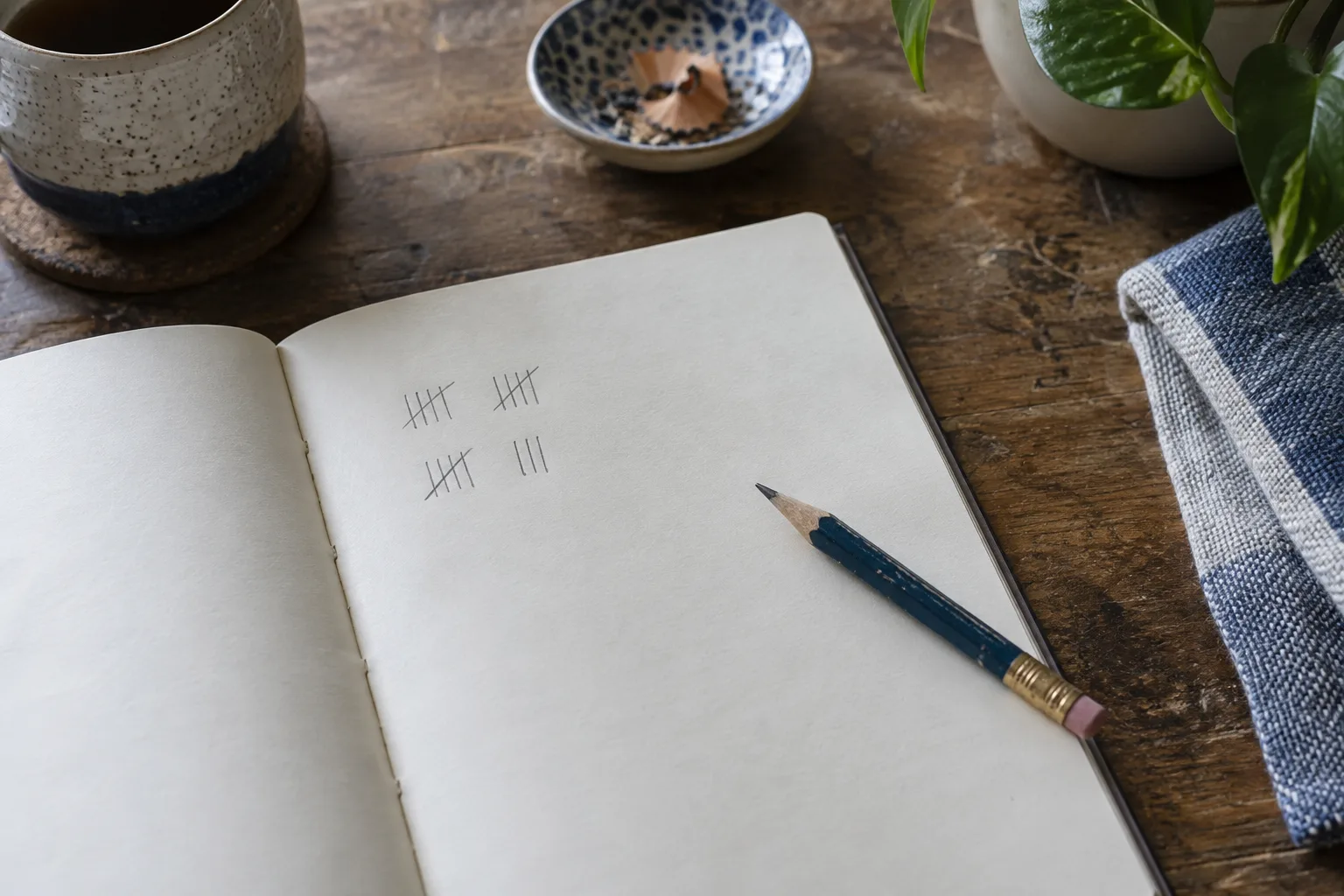 A notebook with a pencil and a few simple tick marks