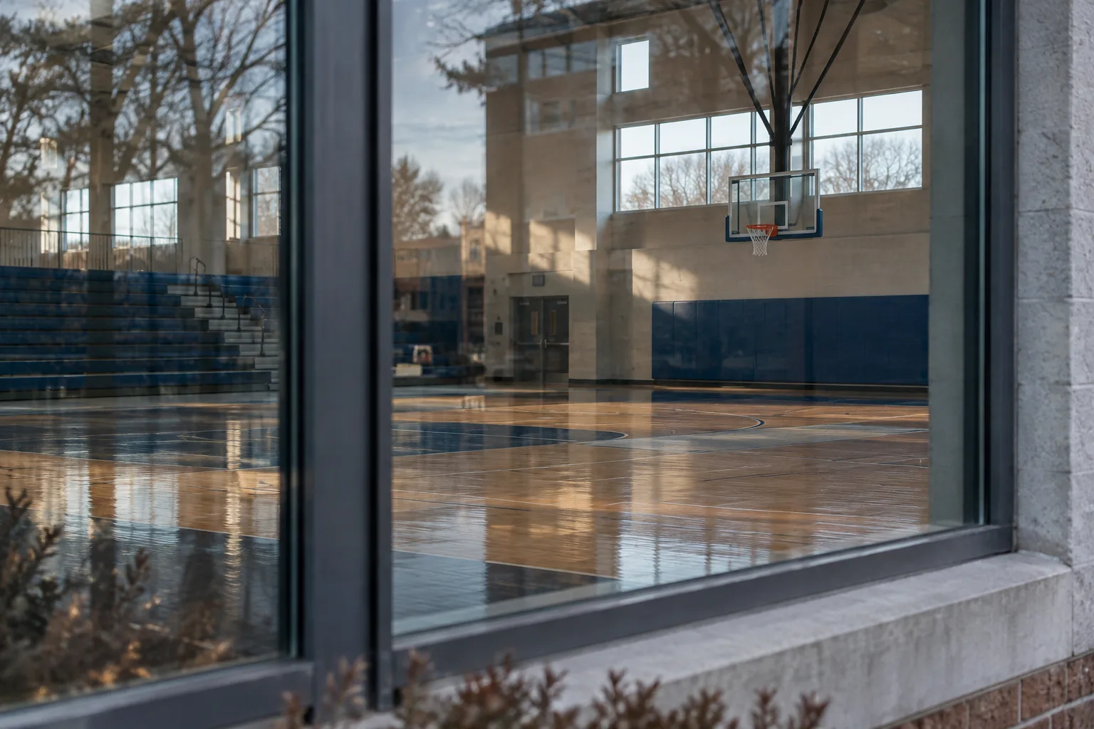 A basketball court reflected in a gym window